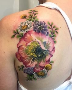 a woman's back with flowers and leaves on it