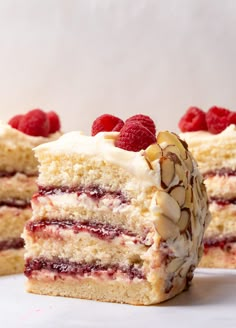 a piece of cake with raspberries and almonds on top is cut in half