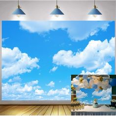 an empty room with blue sky and white clouds on the wall, as well as balloons floating in the air