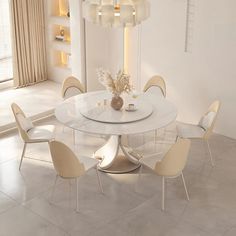 a white dining room table with chairs around it