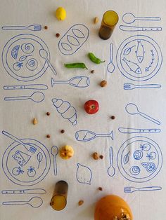 a table topped with lots of food and utensils on top of a white cloth