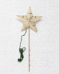 a gold star on a stick with string attached to the end, against a white background