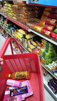 a shopping cart in a grocery store filled with snacks and confection items for sale