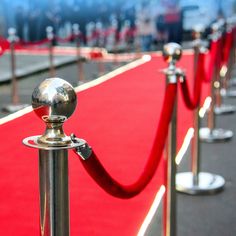 a red carpeted area with metal poles and barriers