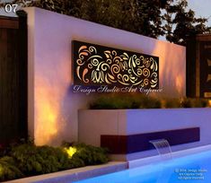 an outdoor swimming pool at night with lights on the wall and planters around it