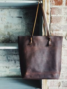 Looking for something deep and rustic? Here’s your dream bag for all day, every day. With a large interior pocket and adjustable knotted straps you’re good to go. Optional snap closure. 15” w by 14” h by 4” Brown Crossbody Bag With Rolled Handles, Rustic Brown Tote Bag, Rustic Brown Bag For Everyday Use, Rustic Leather Shoulder Bag For Everyday Use, Rustic Shoulder Bag With Leather Handles For Travel, Rustic Everyday Tote Bag, Rustic Crossbody Bag For Everyday Use, Rustic Tote Bag For Everyday Use, Rustic Bags With Leather Handles For Everyday