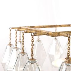 several clear glass hanging vases with chains attached to the bottom and gold chain around them