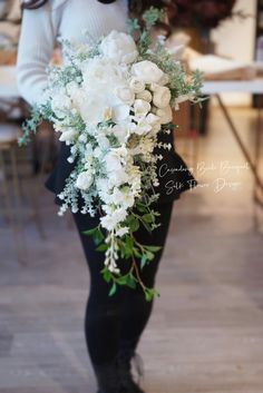 a woman holding a bouquet of white flowers