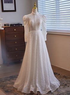 a wedding dress on display in front of a window