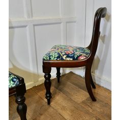 a wooden chair with a floral upholstered seat and foot rest on a hard wood floor