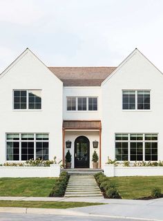 a large white house with many windows and steps leading up to the front door area