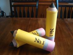 two yellow crayons sitting on top of a wooden table next to each other