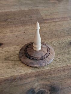 a white chess piece sitting on top of a wooden table