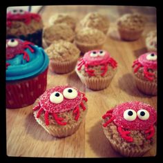 some cupcakes with googly eyes are on a table