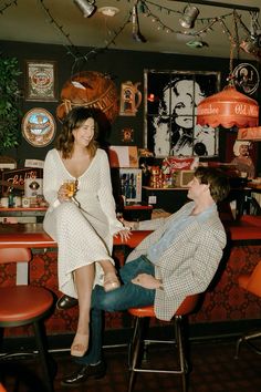 a man and woman sitting at a bar