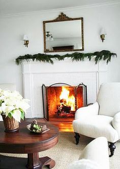 a living room filled with furniture and a fire place under a mirror on the wall