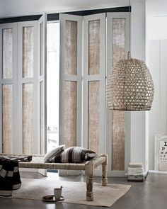 a living room filled with furniture and windows covered in shades of natural bamboo coverings