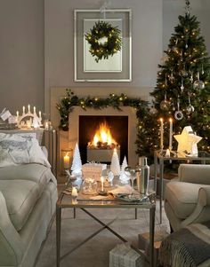 a living room filled with furniture and a fire place in front of a christmas tree