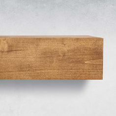 a wooden shelf on the side of a wall with a light brown wood grained finish