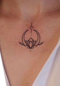 a woman's chest with a lotus tattoo on her left side, and a cross in the middle