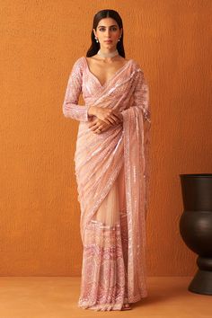 Rose pink net saree with pearl, tonal sequin and crystal embroidery in stripe pattern. Paired with full sleeve embroidered blouse and underskirt.
Components: 3
Pattern: Embroidery
Type Of Work: Pearl, sequin, crystal, stripe
Neckline: Leaf neck
Sleeve Type: Full sleeves
Fabric: Net
Color: Pink
Other Details: 
Back tassel tie-up
Sheer panelled saree
Occasion: Bride - Aza Fashions Full Sleeve Saree Blouse, Full Sleeve Saree, Full Sleeve Blouse Designs, Pink Net Saree, Pearl Saree, Saree Net, Net Saree Blouse, Full Sleeves Blouse Designs, Netted Blouse Designs