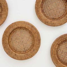 four woven coasters are arranged in the shape of circles on a white table top