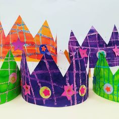 three colorful paper crowns sitting next to each other