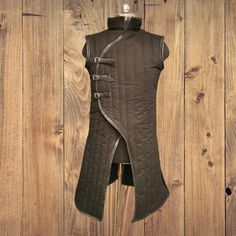 Medieval Sleeveless Padded Gambeson. Materials: Pure Cotton, Leather. Size Details:- Small - Chest-37" Length From Shoulder- 43" Medium # Chest-41" Length From Shoulder- 43 Large # Chest-45" Length From Shoulder- 44" X-Large # Chest-47" Length From Shoulder- 44" 2X-Large # Chest-50" Length From Shoulder- 45" 3X-Large # Chest-54" Length From Shoulder- 45" 4X-Large # Chest-56" Length From Shoulder- 45" 5X-Large # Chest-58" Length From Shoulder- 46" Medieval Style Black Vest For Larp, Black Medieval Vest For Larp, Gothic Sleeveless Vest Outerwear, Gothic Sleeveless Outerwear For Winter, Gothic Sleeveless Winter Outerwear, Sleeveless Gothic Outerwear For Winter, Fitted Sleeveless Vest For Larp, Gothic Fitted Sleeveless Outerwear, Bracers Armor