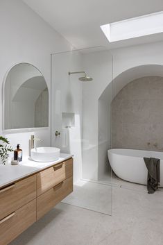 a bathroom with a tub, sink and mirror in the middle of it's walls