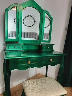 a green dressing table with mirror and stool