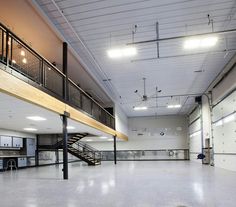 an empty building with stairs and lights in the ceiling is seen from across the room