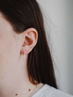 Delicate and dainty, the sterling silver chain attaches to both stud and post to create a unique hugged ear chain design - as unique and beautiful as the wearer.Material: Sterling silver. Hello Adorn makes beautiful minimalist everyday jewelry by hand in Eau Claire, Wisconsin. Silver Sterling Wedding Piercings, Minimalist Ear Climbers For Gift, Dainty Pierced Ear Climbers As A Gift, Classic Sterling Silver Ear Climbers For Gift, Delicate Sterling Silver Huggie Earrings For Wedding, Classic Sterling Silver Ear Climbers As Gift, Dainty Silver Huggie Earrings For Wedding, Dainty Sterling Silver Huggie Earrings For Wedding, Sterling Silver Huggie Piercings For Anniversary