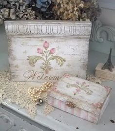 an old dresser with lace and pearls on it next to a vase filled with flowers