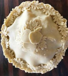 a pie with white frosting on it sitting on top of a wooden table