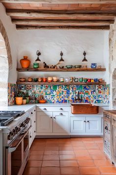 a kitchen with white cabinets and colorful tiles on the backsplash, along with an oven