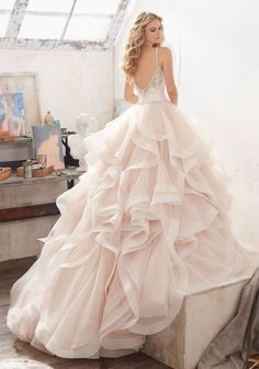 a woman in a wedding dress is standing on a step with her back to the camera