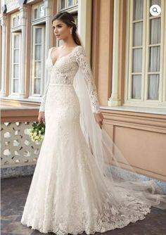 a woman in a wedding dress standing outside