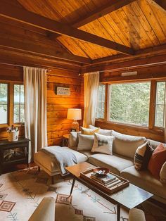 a living room filled with furniture and windows covered in wooden paneling next to a fire place