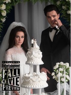 a man and woman standing in front of a wedding cake with the bride holding her finger to her mouth