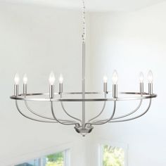 a chandelier with six lights hanging from the ceiling in a white living room