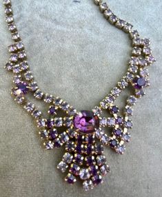 "Vintage Purple Rhinestone Choker Necklace. Size: 14\", Center- 1 1/2\"x 1 5/8\". Markings: None. Striking. Sold as is. Pr-Owned." Red Garnet Ring, Rhinestone Choker Necklace, Rhinestone Choker, Bib Necklaces, Purple Rhinestone, Vintage Purple, Necklace Size, Garnet Rings, Long Beach