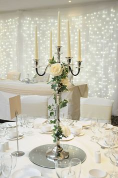 a table set with candles and flowers on it for a wedding reception or special event