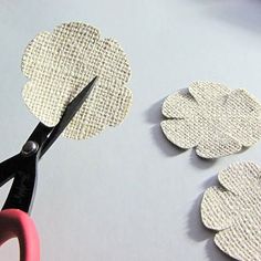 the scissors are cutting paper flowers out of fabric to make them look like they have been cut