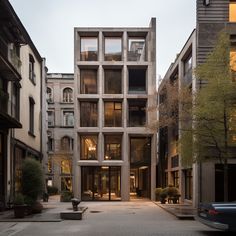 the building is made out of concrete and has many windows on each side, as well as several balconies