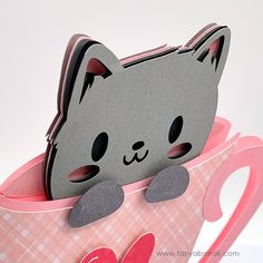 a close up of a paper cut out of a cat in a cup with hearts