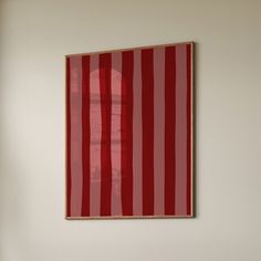 a red and white painting hanging on the wall