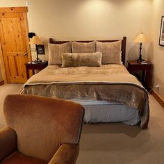 a bedroom with a bed, chair and pictures on the wall