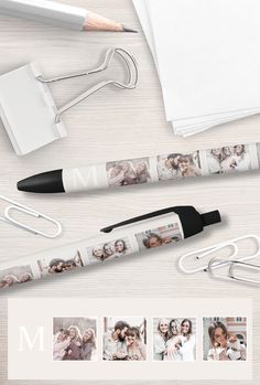 an umbrella with photos on it next to a pen and paper clip, which has the letter m