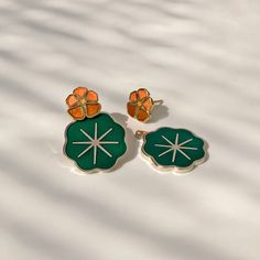 "Nasturtiums, who colored you, you wonderful, glowing things? You must have been fashioned out of summer sunsets." —Lucy Maud Montgomery enamel flower studs with leaf ear jackets0.4 inch stud, 1 inch with jacketgold plate flowers, silver plated leavesnickel-free post & butterfly claspsold as pair Nasturtium Wedding, Laser Wood Earrings, Jewellery Designing, 70s Earrings, Artsy Earrings, Cool Earrings, Plate Flowers, Jacket Earrings, Earring Jackets