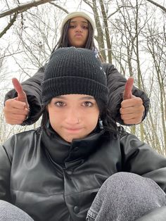 a woman giving the thumbs up while sitting next to a man in a leather jacket